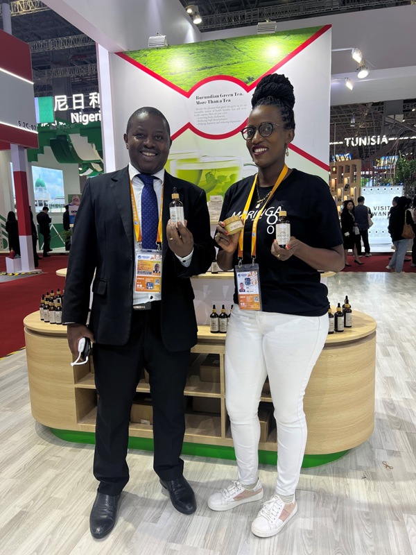 Bulimaso Alfred （kushoto）, konsuli wa kwanza wa ubalozi wa Burundi mjini Beijing na Kamariza Estella (kulia), mwonyeshaji bidhaa, wakionyesha mafuta ya kupakaa ya moringa, yaliyotengenezwa kutokana na mmea wa kienyeji uitwao moringa kwenye banda la Burundi la Maonyesho ya 7 ya Kimataifa ya Uagizaji Bidhaa ya China (CIIE) mjini Shanghai, Novemba, 6, 2024. (People