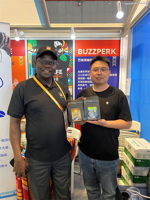 Joseph Nkandu mkulima wa kahawa kutoka Uganda ambaye pia ni Mkurugenzi Mtendaji wa Shirika la Wakulima wa Kahawa la Uganda akiwa na mbia wake Mchina kwenye banda lao. (People’s Daily Online)