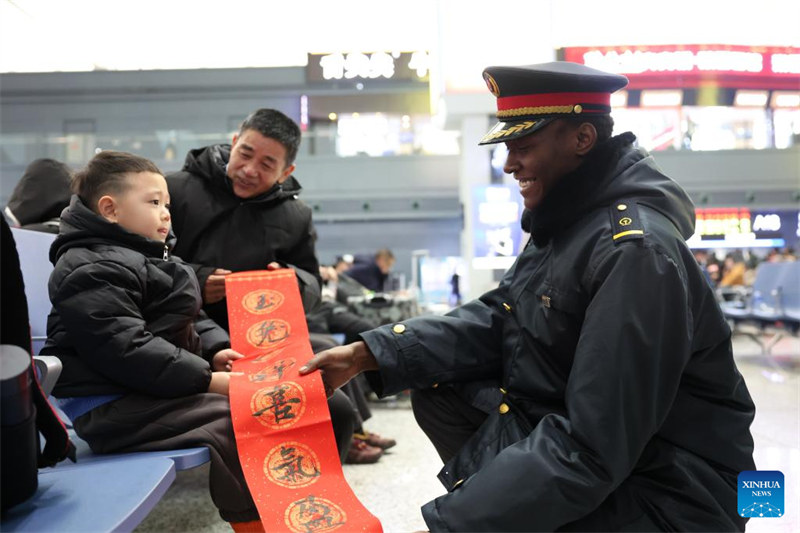 Wanafunzi wa kigeni wawa watu wa kujitolea wa Stesheni ya Treni ya Lanzhou katika pilika za kuwahudumia wasifiri wakati wa Mwaka Mpya wa Jadi wa China