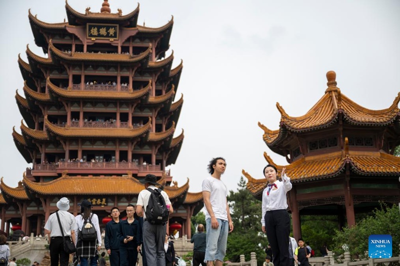 Mwelekezaji watalii Hu Yanan (kulia, mbele) akitoa huduma kwa lugha ya Kiingereza kwa mtalii wa Misri Khaled Metwally Abdelhay Mohamed (kushoto, mbele) kwenye Mnara wa Korongo wa Njano, au Huanghelou, kivutio cha kihistoria mjini Wuhan, Mkoa wa Hubei, katikati mwa China, Aprili 30, 2025.  (Xinhua/Wu Zhizun)