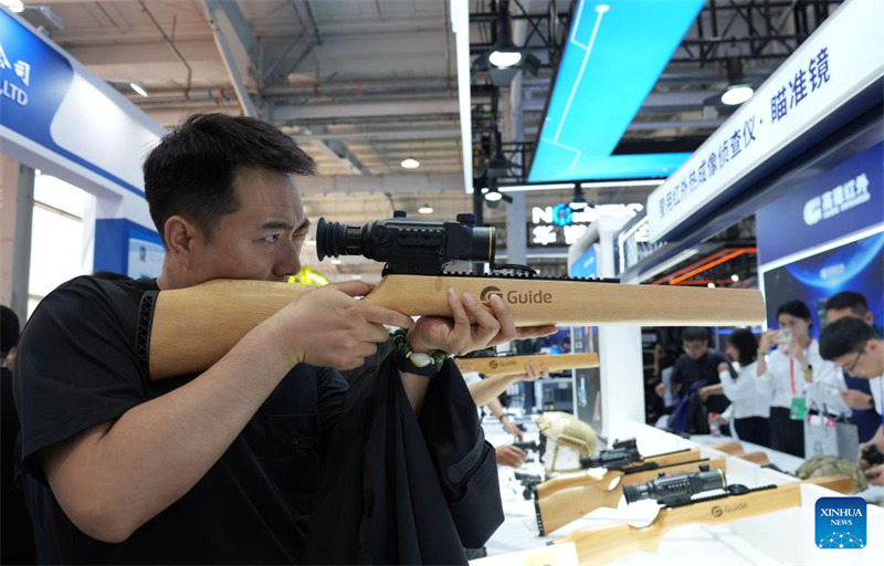 Mtembeleaji akijaribu kifaa cha kulenga kinachotumia mwanga wa infrared  kwenye Maonyesho ya 12 ya Kimataifa ya Zana za Polisi ya China hapa Beijing, mji mkuu wa China, Mei 14, 2025.(Xinhua/Cai Yang)