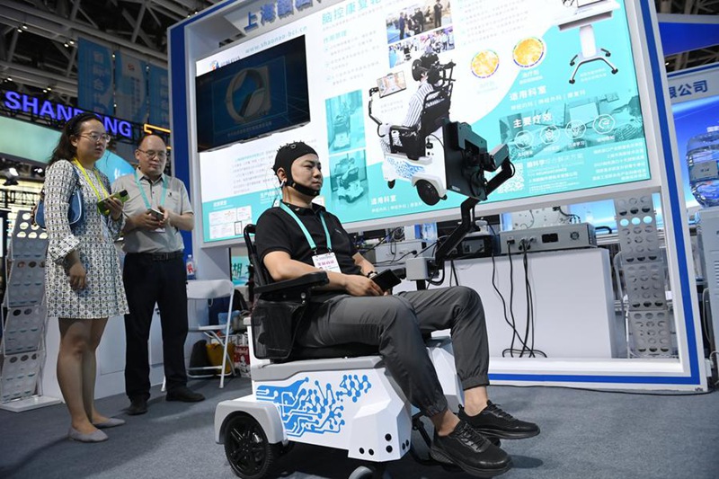 Mfanyakazi akionyesha namna ya kutumia kiti cha magurudumu cha kuimarisha afya ya mwili baada ya kuugua kwenye Maonyesho ya 9 ya Kimataifa ya Njia ya Hariri na Jukwaa la Uwekezaji na Biashara la Ushirikiano kati ya maeneo ya mashariki na magharibi ya China vinavyofanyika Xi'an, Mkoa wa Shaanxi, kaskazini-magharibi mwa China, Mei 21, 2025. (Xinhua/Li Yibo)