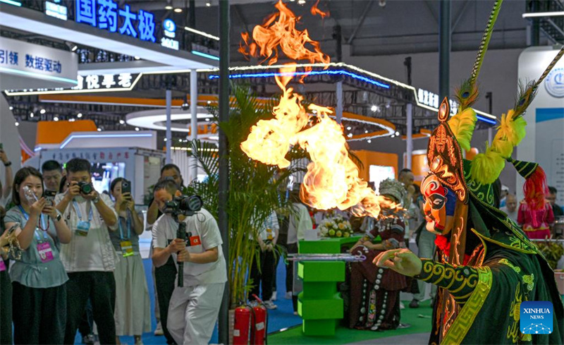 Watembeleaji maonyesho wakitazama onyesho la Bianlian (kubadilisha sura), sehemu ya opera ya Sichuan, kwenye Maonyesho ya 7 ya Kimataifa ya Uwekezaji na Biashara ya Eneo la Magharibi ya China mjini Chongqing, kusini magharibi mwa China, Mei 22, 2025. (Xinhua/Chen Cheng)