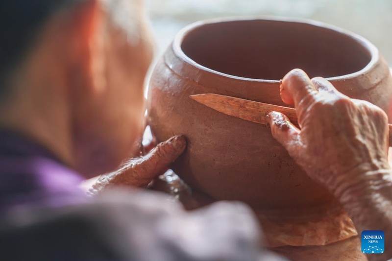 Mwanakijiji akitengeneza sanaa ya ufinyanzi wa udongo wa watu wa kabila la Wali kwenye ushirika wa ufinyanzi katika Kijiji cha Heitu cha Sanya, Mkoa wa Hainan, kusini mwa China, Juni 9, 2025.(Xinhua/Zhang Liyun)