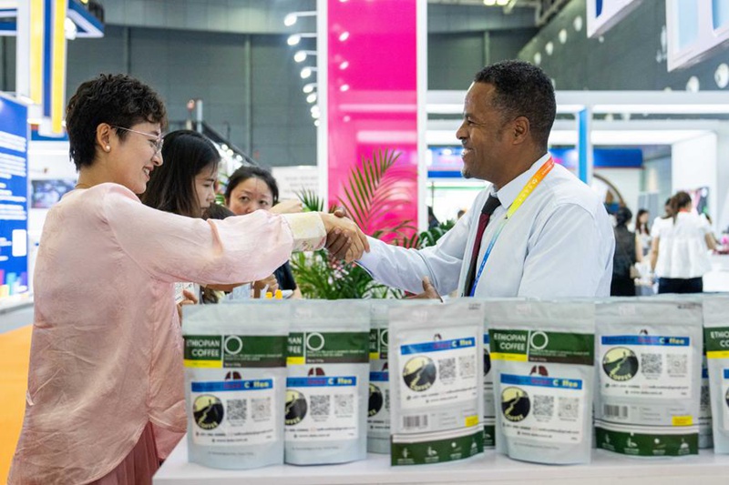 Muonyeshaji bidhaa (kulia) akipeana mkono na mtembeleaji kwenye Maonyesho ya nne ya   Uchumi na Biashara   ya China na Afrika kwenye Kituo cha Mikutano na Maonyesho ya Kimataifa cha Changsha  katika Mkoa wa Hunan, katikati mwa China, Juni 13, 2025. (Xinhua/Chen Sihan)