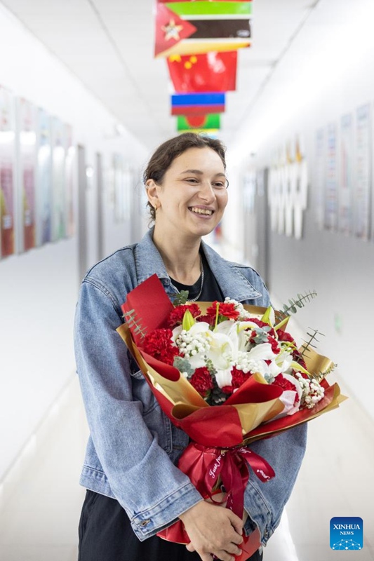Gubaidullina Shakhnaz Evgenevna akiwa ameshika maua katika Chuo Kikuu cha Huzhou katika Mkoa wa Zhejiang, mashariki mwa China, tarehe 24 Juni 2025. (Picha na Yi Fan/Xinhua)