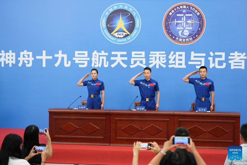 Wanaanga Cai Xuzhe (katikati), Song Lingdong (kulia) na Wang Haoze  waliotekeleza jukumu la chombo cha Shenzhou-19 cha China cha kubeba binadamu kufanya safari kwenye anga ya juu    wakipiga saluti kwenye mkutano na waandishi wa habari mjini Beijing, Julai 9, 2025. (Xinhua/Li Yanchen)