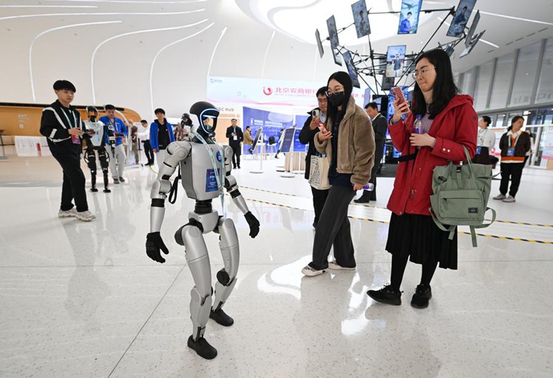 Watu wakipiga picha za roboti yenye umbo la binadamu ya Unitree's G1 kwenye Kituo cha Kimataifa cha Uvumbuzi cha Zhongguancun mjini Beijing, mji mkuu wa China, Machi 26, 2025. (Xinhua/Chen Zhonghao) 