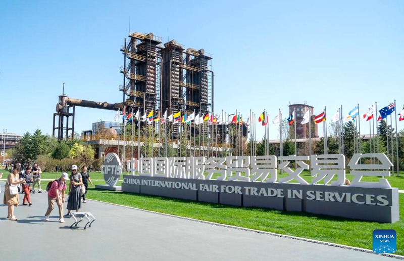 Watu wakiwa pamoja na roboti ya mbwa wakati wa Maonyesho ya Kimataifa ya Biashara ya Huduma ya China 2025 (CIFTIS) kwenye Bustani ya Shougang mjini Beijing, China, Septemba 14, 2025. (Xinhua/Ding He)