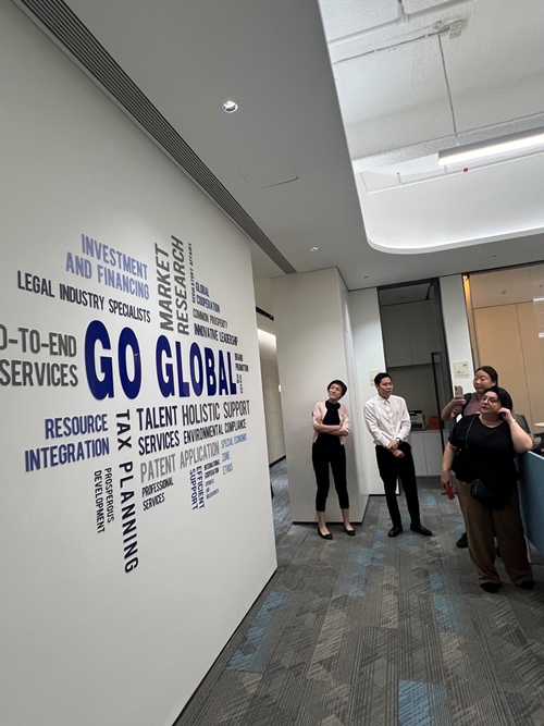 Waandishi wa habari wakitazama bango ukutani linaloeleza huduma mbalimbali zinazotolewa na Kituo cha Huduma za Kimataifa “Go Global” cha Nanshan, Shenzhen, China. (Picha/People’s Daily Online)