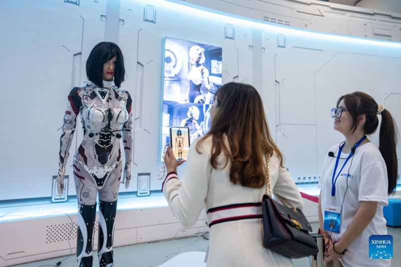 Mtembeleaji maonyesho (wa pili kulia) akifahamishwa kuhusu roboti yenye muundo wa binadamu inayoonyeshwa kwenye Mkutano wa 4 wa Kimataifa juu ya Matumizi ya BDS mjini Zhuzhou, Mkoani Hunan, katikati mwa China, Septemba 24, 2025. (Xinhua/Chen Sihan)