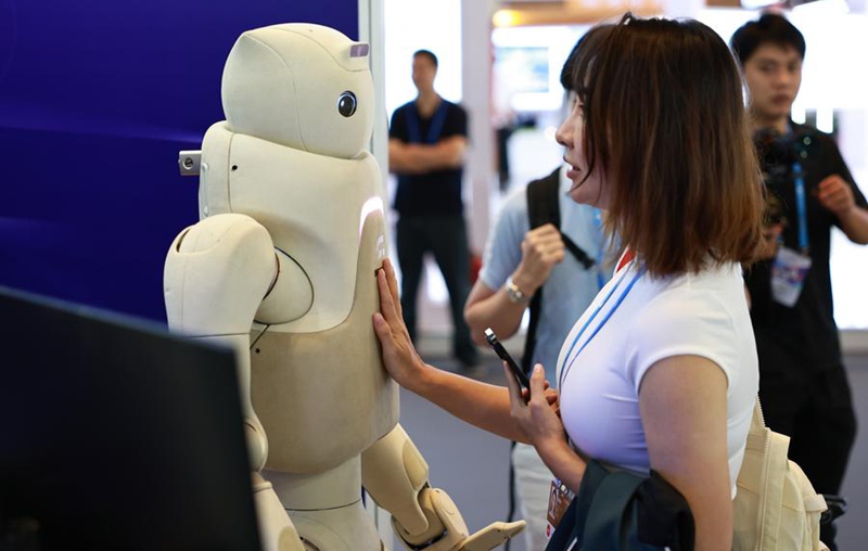 Mtembeleaji maonyesho akiwasiliana na roboti kwenye Baraza la Uvumbuzi la Pujiang 2025 lililofanyika mjini Shanghai, mashariki mwa China, Septemba 21, 2025. (Xinhua/Fang Zhe)