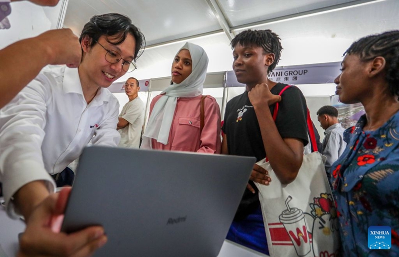 Mwajiri akitumia kompyuta ya mkononi kuonyesha maelezo ya kazi na taarifa za kampuni kwa waombaji kazi kwenye Maonyesho ya tano ya Kazi ya China na Tanzania jijini Dar es Salaam, Tanzania, Juni 16, 2026. (Xinhua/Emmanuel Herman)