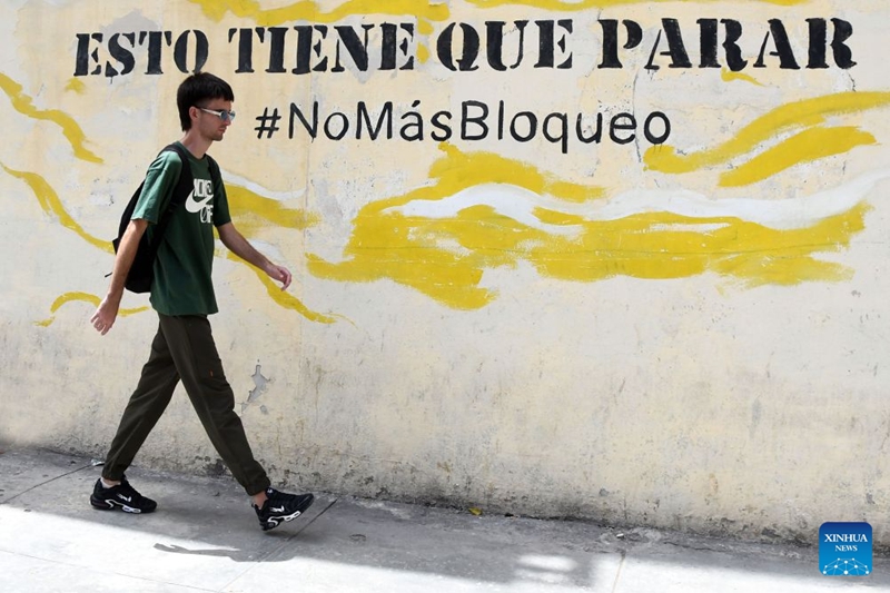Jamaa akitembea kuipita kauli mbiu inayopinga kizuizi cha Marekani, mjini Havana, mji mkuu wa Cuba, Julai 8, 2026. (Picha na Joaquin Hernandez/Xinhua)