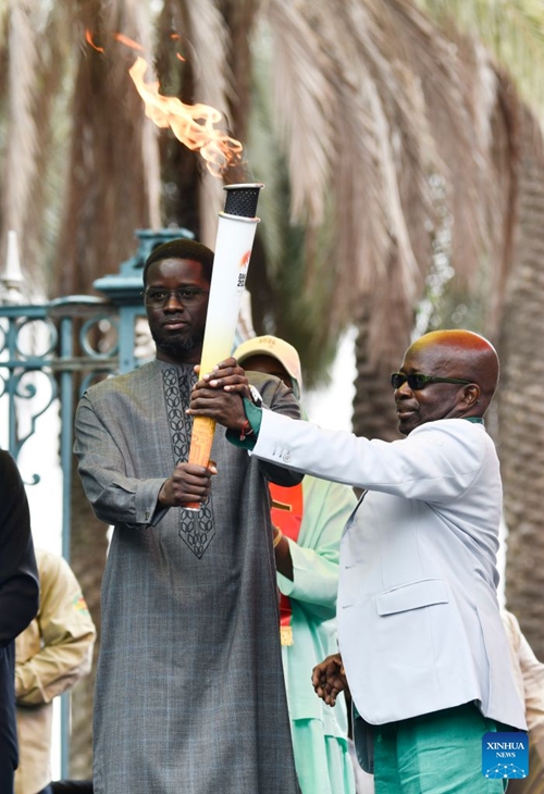 Rais wa Senegal Bassirou Diomaye Faye (kushoto) akipokea mwenge kutoka kwa Mamadou Diagna Ndiaye, mwenyekiti wa Kamati ya Maandalizi ya Michezo ya Olimpiki ya Vijana ya Dakar 2026, kwenye hafla ya kuupokea mwenge wa michezo hiyo nje ya Ikulu ya Rais jijini Dakar, Senegal, Septemba 12, 2026. (Picha na Papa Demba Gueye/Xinhua)
