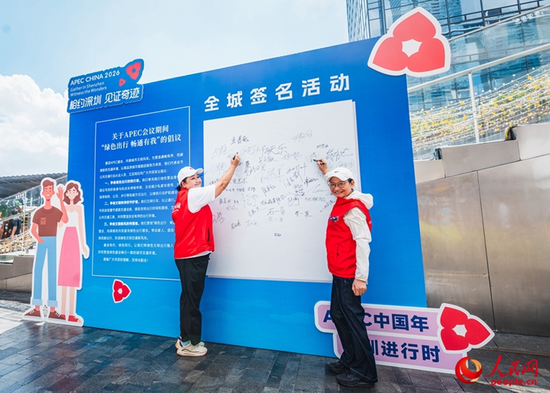 Wakazi wa Shenzhen wakitia sahihi kwenye ubao wa sahihi kuonyesha kuunga mkono usafiri wa kijani. (People's Daily Online/Wang Xing)