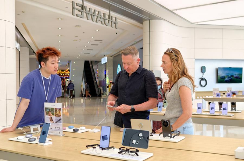 Tarehe 30 Aprili 2026, watalii wa kigeni wakichagua vitu katika duka kuu la Huawei jijini Beijing. (Xinhua/Ju Huanzong)
